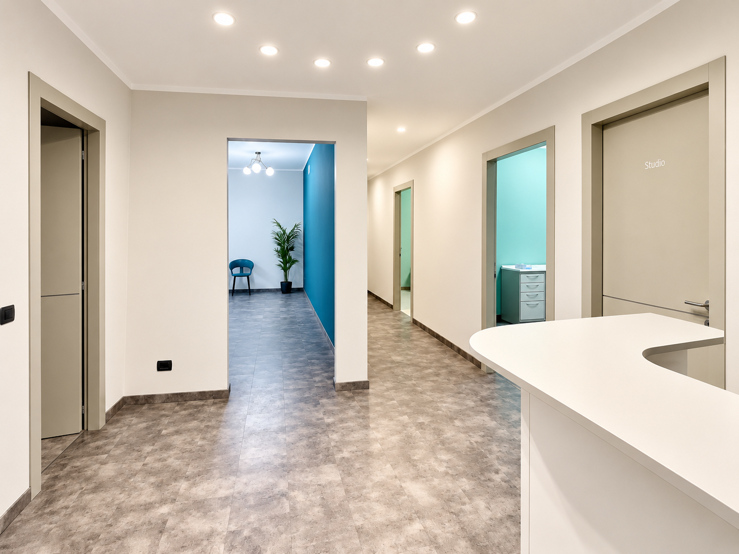 Spazi dello Studio Medico Calliope: corridoio luminoso con reception, pavimentazione chiara e ambienti dai toni verde acqua